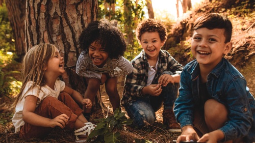 A group of young kids playing in the woods.