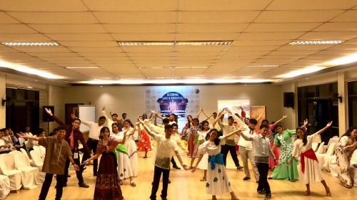 a group of teenagers wearing traditional costumes and dancing