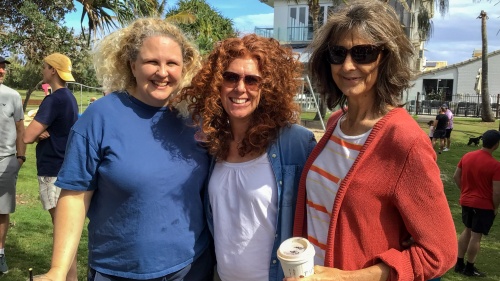 three ladies smiling as they stand outdoors