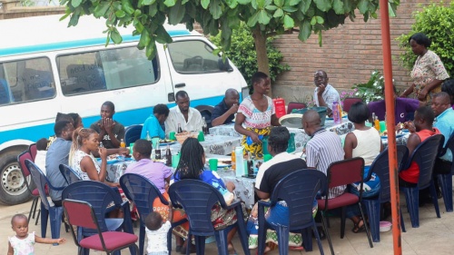 a group of people eating outdoors in front of a van