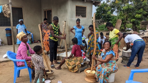 a group of brethren sitting outside a house in Ghana