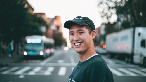 a smiling man with a city street background