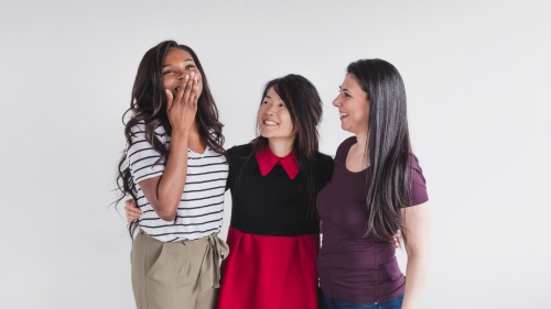 a group of three women smiling and laughing