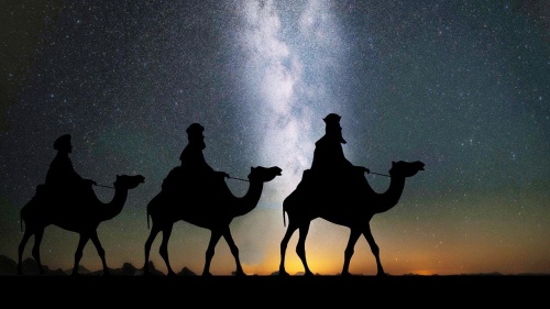 three silhouettes of men on camels against a starry night sky