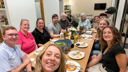 a group of people gathered around a table with food