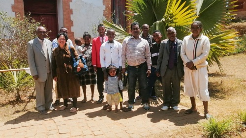 a group of people standing outdoors in front of a building