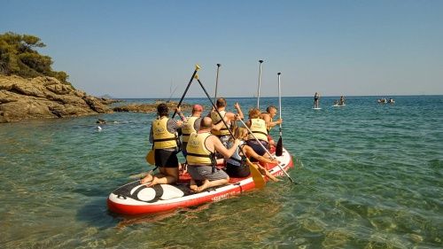 people on an inflatable raft wearing lifejackets and holding paddles while floating on the water