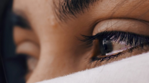 A closeup of a woman's eyes with tears.