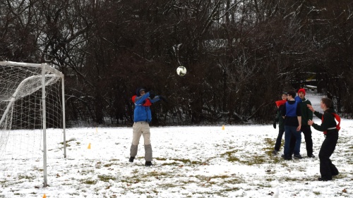 a group of teenagers outside playing speedaway in the snow