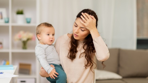 a stressed woman holding a small child