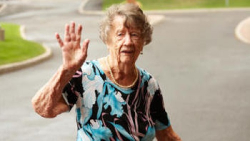 An elderly woman waving.