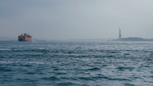 The Statue of Liberty in the distance from the ocean.