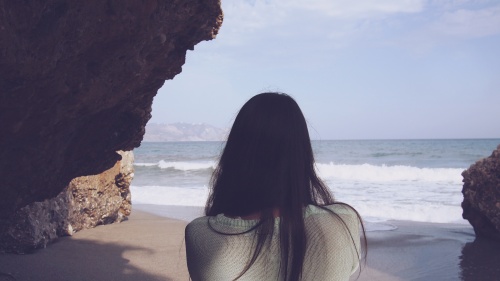 A woman looking at the ocean.
