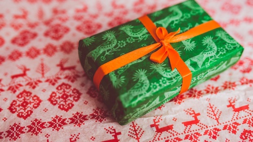 A green present wrapped with red bow.