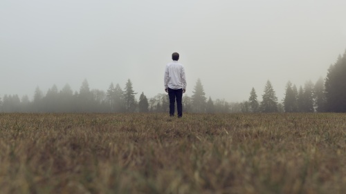 A man standing by himself in an open field.
