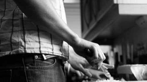 A man preparing food at a kitchen counter.