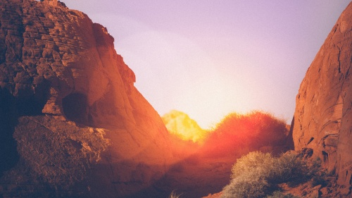 Sun setting behind rocks