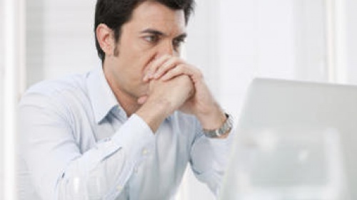 A man looking at his laptop screen.