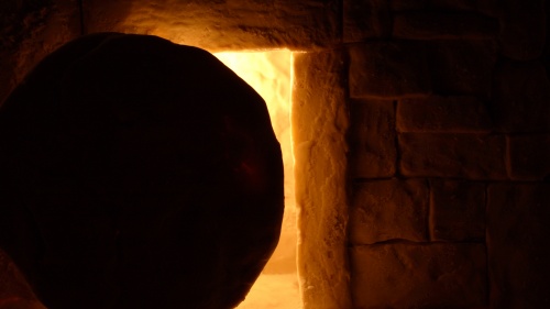 A round stone in front of a tomb entrance.