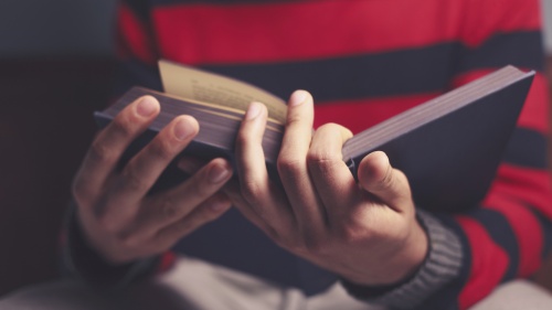 A young man reading a Bible.