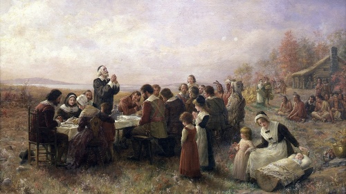 Painting of pilgims giving thanks during a meal.