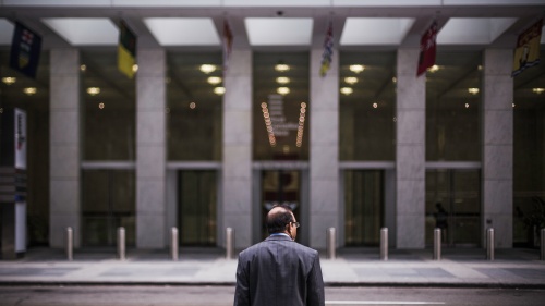 A man across from a big building.