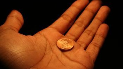hand holding a single penny