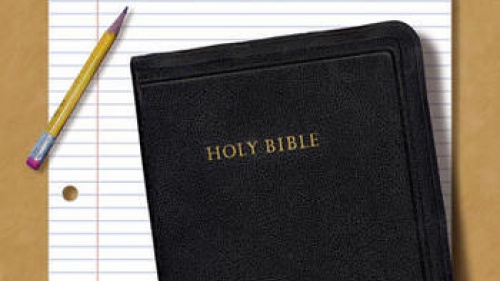 Bible with notepaper and pencil