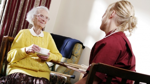 A young woman visiting with an elderly lady.