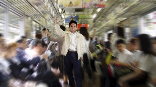 A man surrounded by people on a subway car.