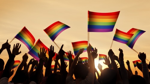 People waving gay pride flags.