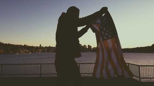 A man holding up the American flag.