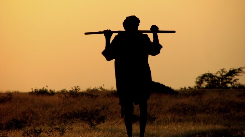 A shepherd carrying a rod.