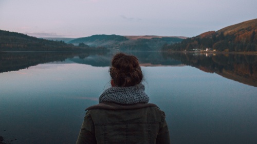 A young woman looking over a lake.