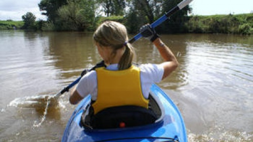 A woman paddling a kayak.