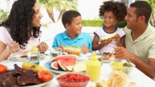 Parents and children around table with BBQ food - What Happened to the Family Me