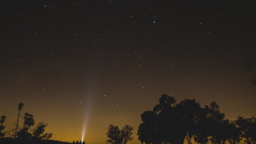 People sitting outside looking up at the stars.