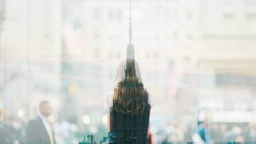 A woman&#039;s silhouette over a city building scape.