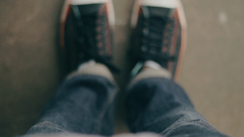 Looking down at the floor and shoes.