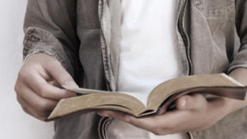A young man holding a Bible.