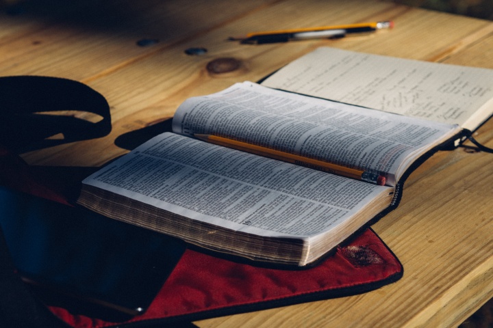 A Bible and notebook laying on a table.