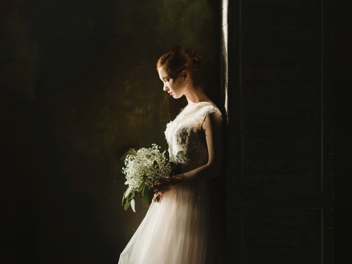 a bride standing alone and looking at the ground