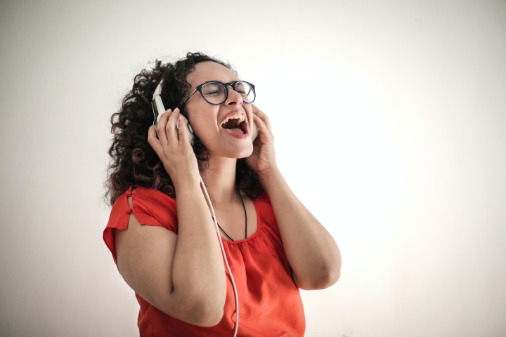 a woman singing and wearing headphones