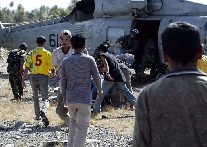 An air crewman, assigned to the "Golden Falcons" of Helicopter Anti-Submarine Squadron Two (HS-2), unload food and water from a SH-60F Seahawk, in Aceh Jaya, Sumatra, Indonesia.