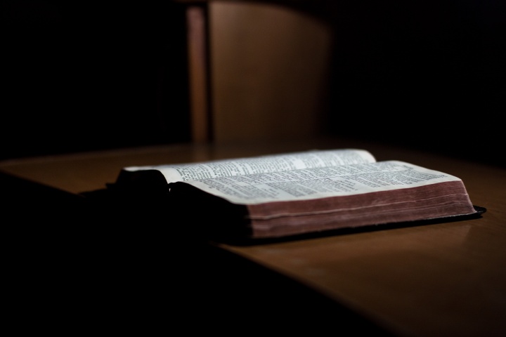 An open Bible laying on a table.