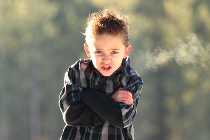 A young boy looking angry.