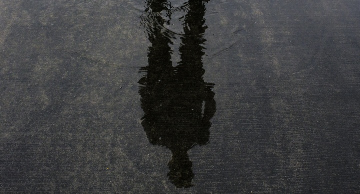 A person's shadow in shallow pool of water.