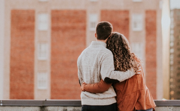 A couple looking out over a wall.