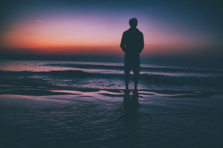 A man walking the tide of the ocean waves.