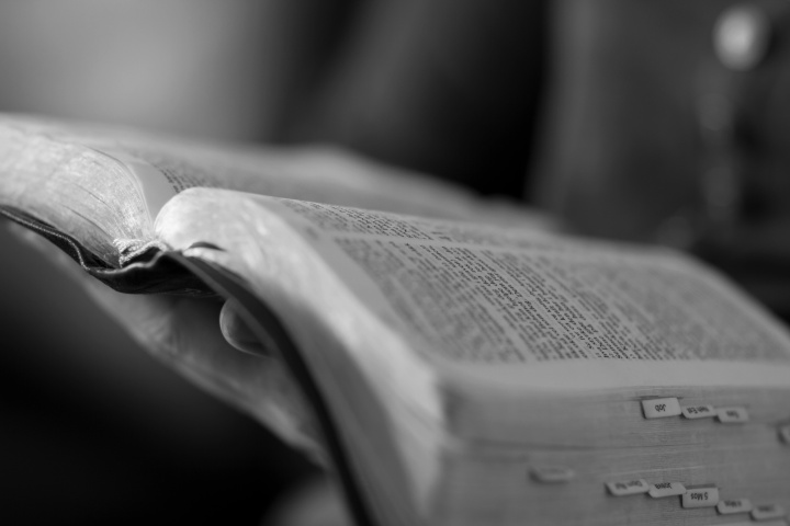 A woman holding an opened Bible.